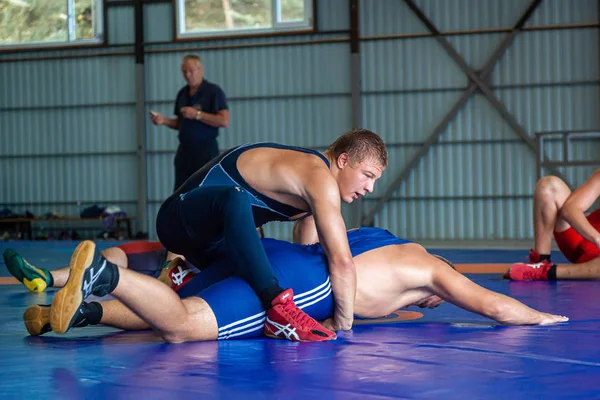 俄罗斯阿尔泰 2019年8月16日 两名穿着摔跤服的年轻人在健身房的蓝色摔跤地毯上在地上摔跤 开放训练和夏季体育营 — 图库照片