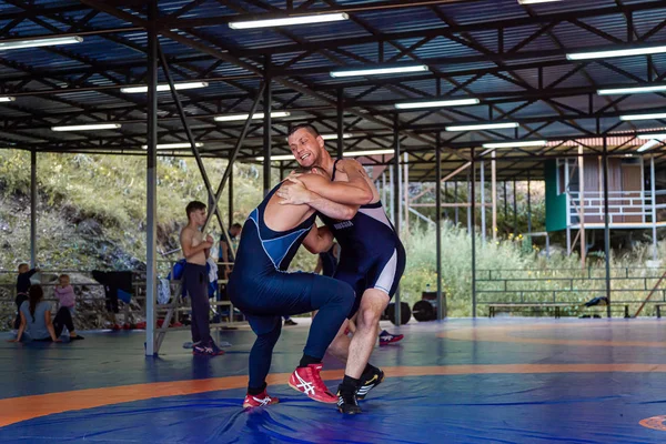 アルタイ ロシア8月16 2019 グレコローマのレスラーは ジムで青いレスリングカーペットのトレーニングでスローとグラブの練習 オープントレーニングとサマースポーツキャンプ — ストック写真