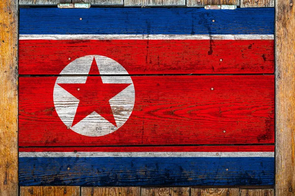 朝鲜国旗在木墙背景上 民族自豪感的概念和国家的象征 用金属钉涂在木栅栏上的旗帜 — 图库照片