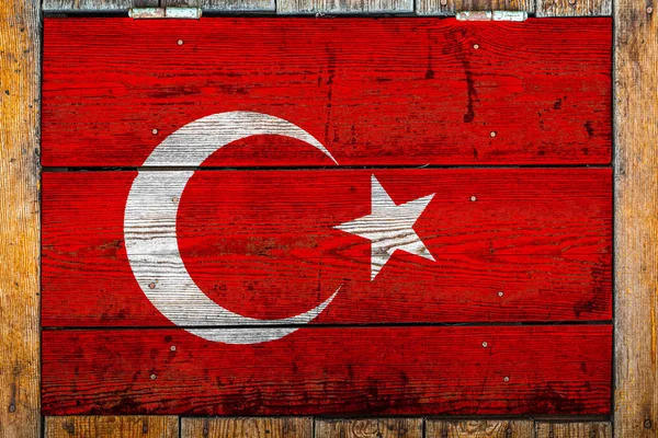 National flag of Turkey on a wooden wall background.The concept of national pride and symbol of the country.Flag painted on a wooden fence with metal nails.
