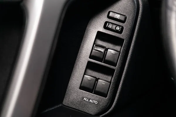 Close-up of the side door buttons: window adjustment buttons, door lock. modern car interior: parts, buttons, knob