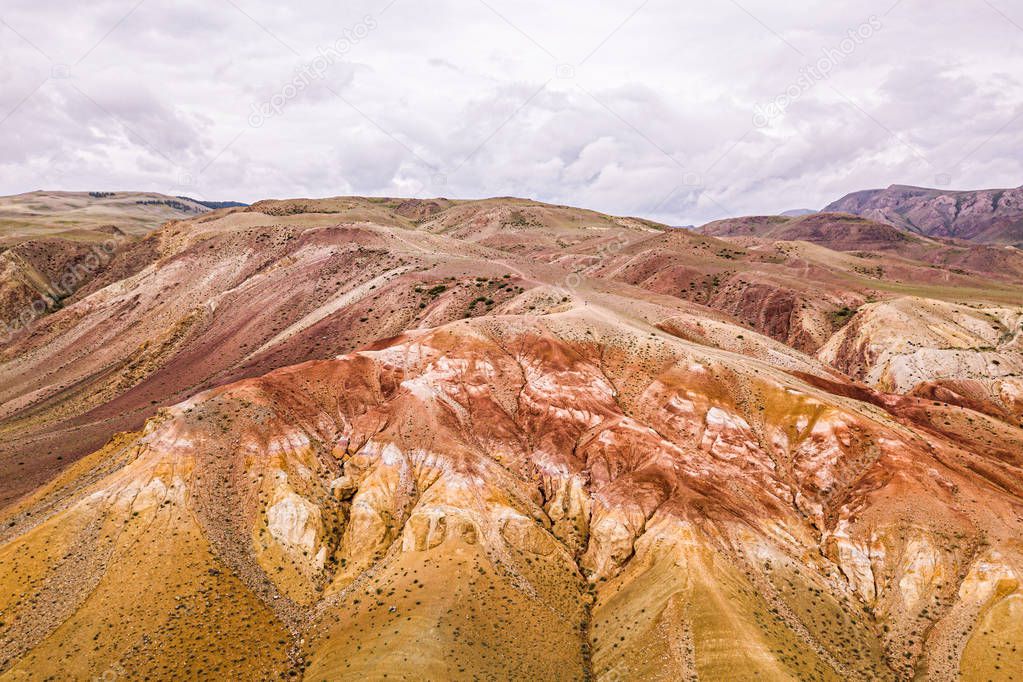 A stunning panorama of a mountain chain of peaks, a canyon with red clay, top view. Mars fields in Altai, Russia