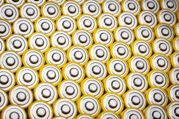 碱性电池 几节电池成行 同一块黄色电池的特写镜头 在一排排上排成一排 正电荷 使用能源的不安全方式 — 图库照片