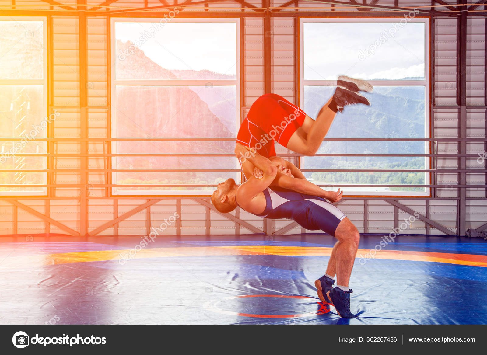 Two men in sports wrestling tights and wrestling during a traditional  Greco-Roman wrestling in fight on a wrestling mat. Wrestler throws his  opponent's chest through Photos