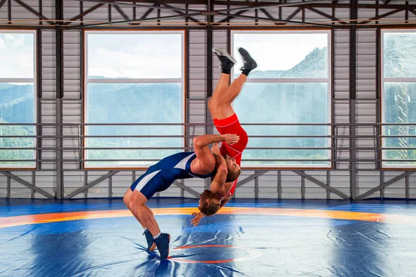 フェアレスリングのコンセプト スポーツウェアを着た2人のグレコローマンのレスラーが ジムのレスリングカーペットの上で胸を投げる 男子レスリングとレジスタンスの概念 — ストック写真