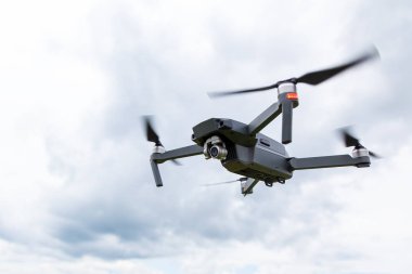 Dron helikopterini kamerayla kapatın. Quadcopter gökyüzü arka planda izole edilmiş. Güneşli bir günde mavi gökyüzüne karşı drone uçuş.