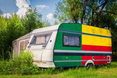 Bir araba römork, bir motor ev, Benin ulusal bayrağı boyalı bir dağlık park halinde duruyor. Ülkeler arasında karayolu taşımacılığı, ticareti, ihracatı ve ithalatı kavramı.