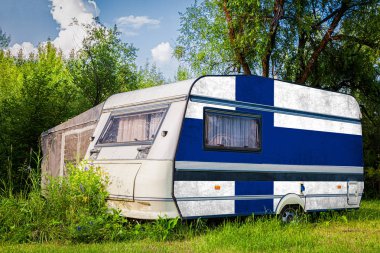 Bir araba römork, bir motor ev, Finlandiya ulusal bayrağı boyalı bir dağlık park halinde duruyor. Ülkeler arasında karayolu taşımacılığı, ticareti, ihracatı ve ithalatı kavramı.