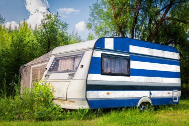 Bir araba römork, bir motor ev, Yunanistan ulusal bayrağı boyalı bir dağlık park halinde duruyor. Ülkeler arasında karayolu taşımacılığı, ticareti, ihracatı ve ithalatı kavramı.