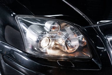 Novosibirsk, Rusya Ağustos 24, 2019: Toyota Avensis, Modern siyah araba xenon lamba far Makro görünümü, tampon, tekerlek. Modern bir arabanın dış
