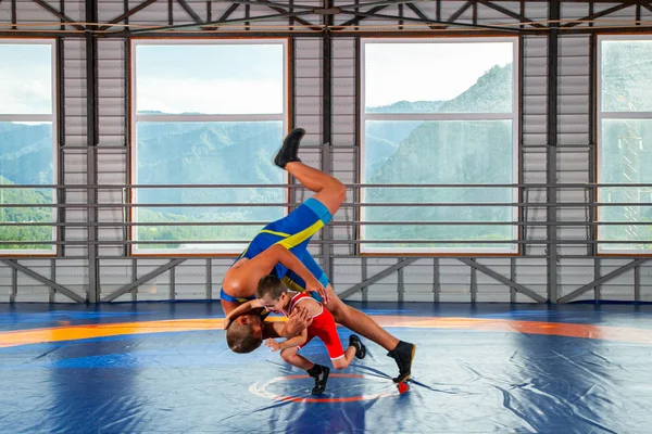 スポーツレスリングタイツのトレーナーは 山に対するグレコローマンレスリングのスタイルで伝統的なレスラーの少年を教えています 武道における子どものスポーツトレーニングの概念 — ストック写真