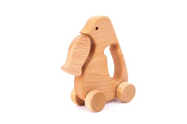 Kayın tekerlekleri üzerinde balık ile ahşap bir penguen fotoğrafı. Beyaz izole bir arka plan üzerinde ahşaptan yapılmış oyuncak. Çocukları eğlendiren ve dinlenen ebeveynler için bir oyuncak