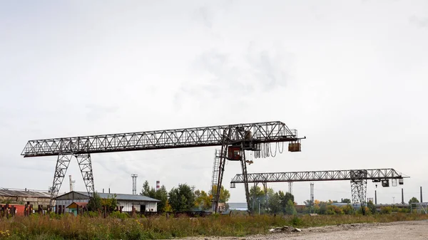 Dois Grandes Guindastes Pórtico Metal Canteiro Obras Fundo Armazéns Industriais — Fotografia de Stock