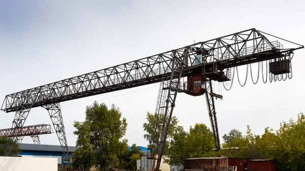 大型金属龙门起重机在建筑工地 在背景工业仓库存放货物 龙门起重机对蓝天的轴承金属结构类型 — 图库照片