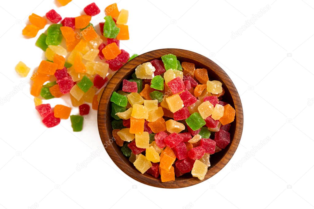  candied  pineapple yellow,   red and green  in a wooden cedar plate on a white isolated background. Row of bowls with dried fruits, pattern, top view.