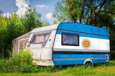 Bir araba römork, bir motor ev, Arjantin ulusal bayrağı boyalı bir dağlık park halinde duruyor. Ülkeler arasında karayolu taşımacılığı, ticareti, ihracatı ve ithalatı kavramı.
