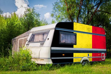 Bir araba römork, bir motor ev, Belçika ulusal bayrağı boyalı bir dağlık park halinde duruyor. Ülkeler arasında karayolu taşımacılığı, ticareti, ihracatı ve ithalatı kavramı.