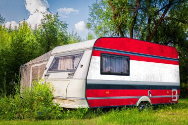 Bir araba römork, bir motor ev, Avusturya ulusal bayrağı boyalı bir dağlık park halinde duruyor. Ülkeler arasında karayolu taşımacılığı, ticareti, ihracatı ve ithalatı kavramı.