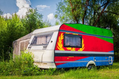 Bir araba römork, bir motor ev, Eritre ulusal bayrağı boyalı bir dağlık park halinde duruyor. Ülkeler arasında karayolu taşımacılığı, ticareti, ihracatı ve ithalatı kavramı.