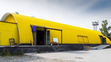 Sarı metal bir deponun cephesi, malların depolanması için ticari bina. İthalatçılar, ihracatçılar, toptancılar, nakliye işletmeleri, gümrük tarafından malların depolama kavramı