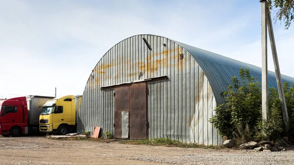 Facade of a gray metal warehouse, commercial building for storage of goods. The concept of storage of goods by importers, exporters, wholesalers, transport enterprises, customs