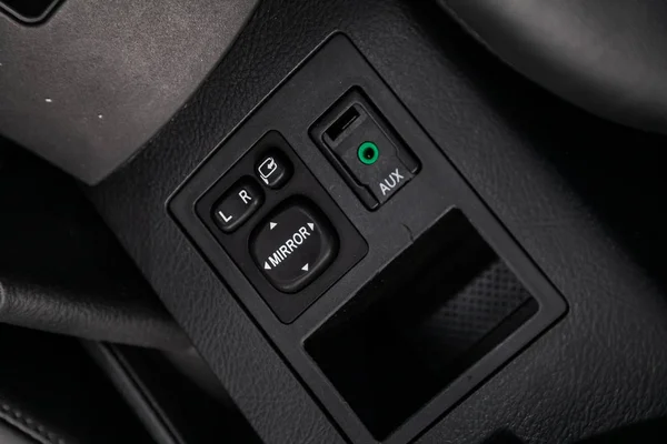 Close-up on the side mirror switch control buttons,  automatic adjust level dashboard and aux, usb connectors. modern car interior: parts, buttons, knob