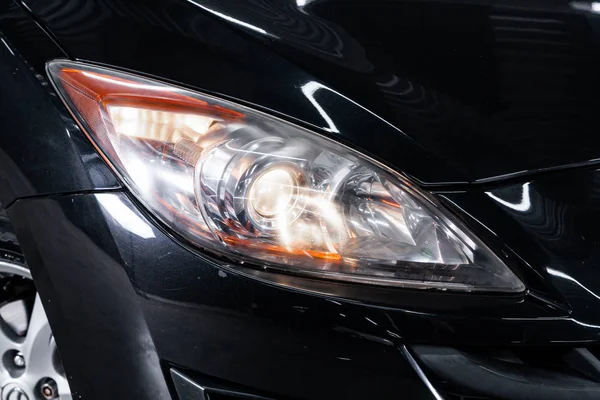 Black car headlights. Exterior detail. Close up detail on one of the LED headlights modern car