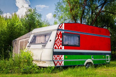 Bir araba römork, bir motor ev, Belarus ulusal bayrağı boyalı bir dağlık park halinde duruyor. Ülkeler arasında karayolu taşımacılığı, ticareti, ihracatı ve ithalatı kavramı.