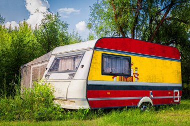 Bir araba römork, bir motor ev, İspanya ulusal bayrağı boyalı bir dağlık park halinde duruyor. Ülkeler arasında karayolu taşımacılığı, ticareti, ihracatı ve ithalatı kavramı.