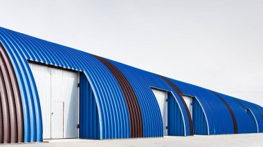 Metal mavi panellerden yapılmış büyük sanayi binasında cephe. Malların taşınması, yüklenmesi ve depolanması nda endüstriyel kavram