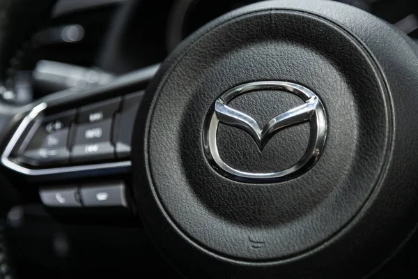 Novosibirsk, Rusya 18 Eylül 2019: yakın çekim, siyah plastik direksiyon üzerinde Mazda isim plakası logosu