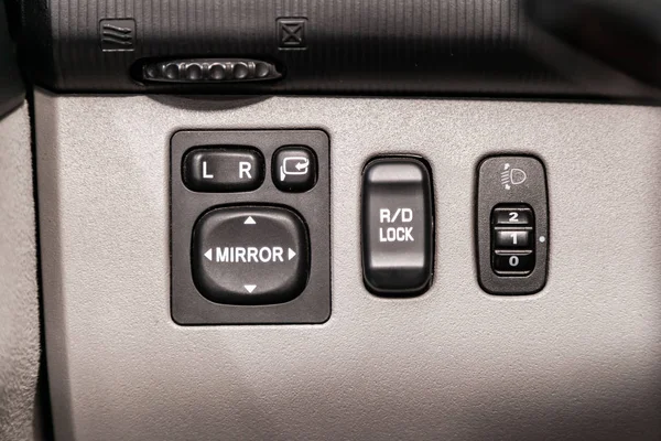 Close-up on the side mirror and headlights switch control buttons,  automatic adjust level dashboard . modern car interior: parts, buttons, knob