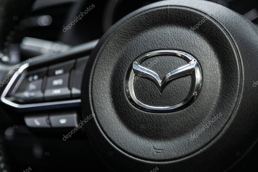 Novosibirsk, Russia  September 18, 2019:  close-up,  Mazda nameplate logo on a black plastic steering wheel