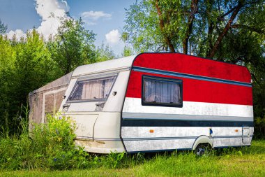 Bir araba römork, bir motor ev, Endonezya ulusal bayrağı boyalı bir dağlık park halinde duruyor. Ülkeler arasında karayolu taşımacılığı, ticareti, ihracatı ve ithalatı kavramı.