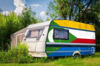 Bir araba römork, bir motor ev, Komor ulusal bayrağı boyalı bir dağlık park halinde duruyor. Ülkeler arasında karayolu taşımacılığı, ticareti, ihracatı ve ithalatı kavramı.