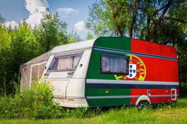 Bir araba römork, bir motor ev, Portekiz ulusal bayrağı boyalı bir dağlık park halinde duruyor. Ülkeler arasında karayolu taşımacılığı, ticareti, ihracatı ve ithalatı kavramı.