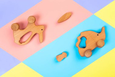 Minimalist düz havuç ile ahşap bir oyuncak tavşan ile yatıyordu, izole bir çok renkli canlı geometrik arka plan üzerinde mantar ile kirpi. Çocuk ve ebeveynleri eğlendirmek için oyuncak