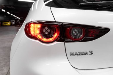 Novosibirsk, Rusya 29 Eylül 2019: yakın çekim, arabanın arka farı, bir tampon, bir baget arka kapağı ve beyaz bir Mazda 3 isim plakası  