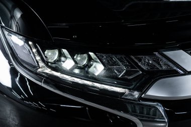 Novosibirsk, Rusya 4 Ekim 2019: Mitsubishi Outlander, siyah araba farları. Dış görev ayrıntıları. Modern arabanın ön farlarından birinin detaylarını kapat. 