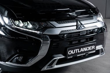 Novosibirsk, Rusya 4 Ekim 2019: Mitsubishi Outlander, farı yakın plan, tampon, tekerlek. Novosibirsk 'te park halindeki modern bir arabanın fotoğrafı.