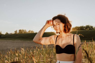 Güneşli bir sonbahar gününde arka planda güzel, genç bir mankenin portresi. Kadınların ve doğanın birliği, barışçıl ruh hali, çevre dostu yaşam.