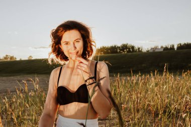 Güneşli bir sonbahar gününde arka planda güzel, genç bir mankenin portresi. Kadınların ve doğanın birliği, barışçıl ruh hali, çevre dostu yaşam.