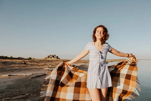 Posing woman in nature. Young woman in blue dress  with a plaid  posing and walking  against the backdrop of a  sea. Photos on summer vacation