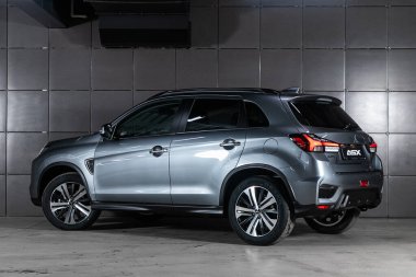 Novosibirsk/ Russia  May 25, 2020:  silver Mitsubishi ASX,back view.  New expensive crossover made in  Japan on parking with black wall  clipart