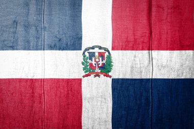 Dominicana 'nın ulusal bayrağı eski kıyafetlerin üzerinde boya renkleriyle tasvir ediliyor. Kumaş dokusu arka planında bayrak pankartı.
