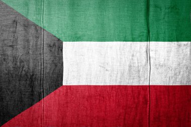 Kuveyt 'in ulusal bayrağı eski tekstil üzerinde boya renkleriyle tasvir ediliyor. Kumaş dokusu arka planında bayrak pankartı.