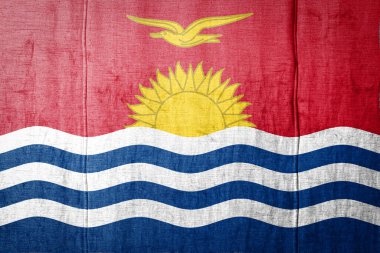 Kiribati 'nin ulusal bayrağı eski tekstil boyalarıyla tasvir ediliyor. Kumaş dokusu arka planında bayrak pankartı.