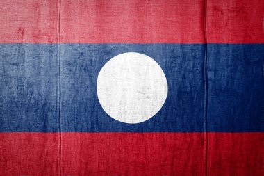 Ulusal Laos bayrağı eski tekstil üzerinde boya renkleriyle tasvir ediliyor. Kumaş dokusu arka planında bayrak pankartı.