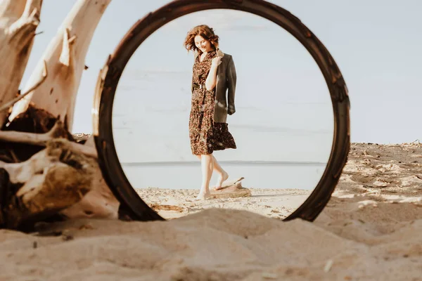 Uśmiechnięta Kobieta Słonecznej Plaży Sukience Trzymająca Kurtkę Rękami Chodząca Lustrze — Zdjęcie stockowe
