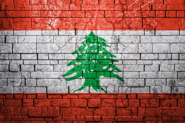 National flag of Lebanon on brick  wall background.The concept of national pride and symbol of the country. Flag  banner on  stone texture background.